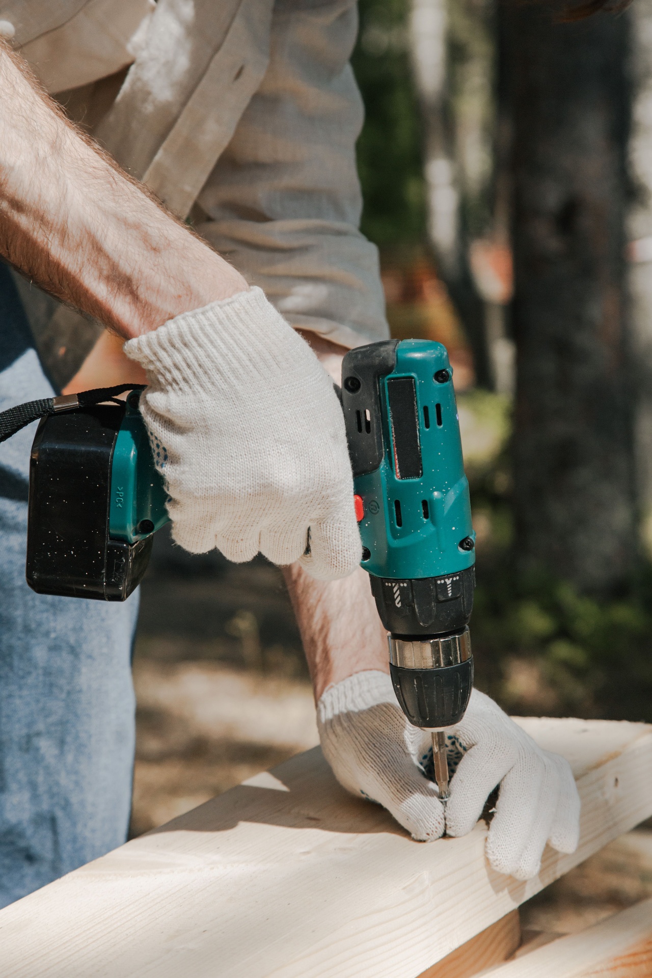 Professional hand tightening a bolt on an oak furniture joint with an allen key